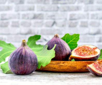 fig fruit on a wooden table with a brick background